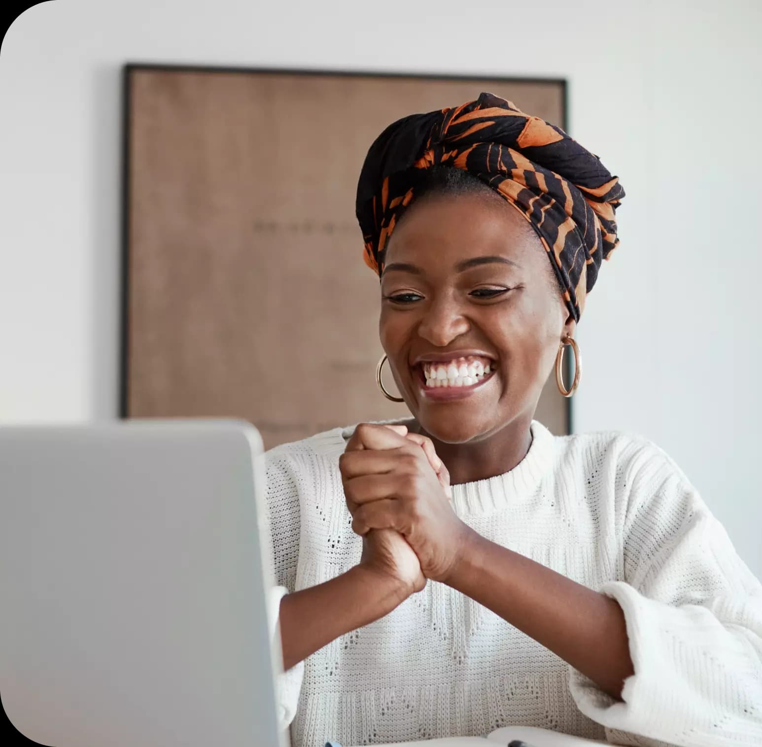 Imagem de uma mulher feliz olhando para a tela de seu notebook